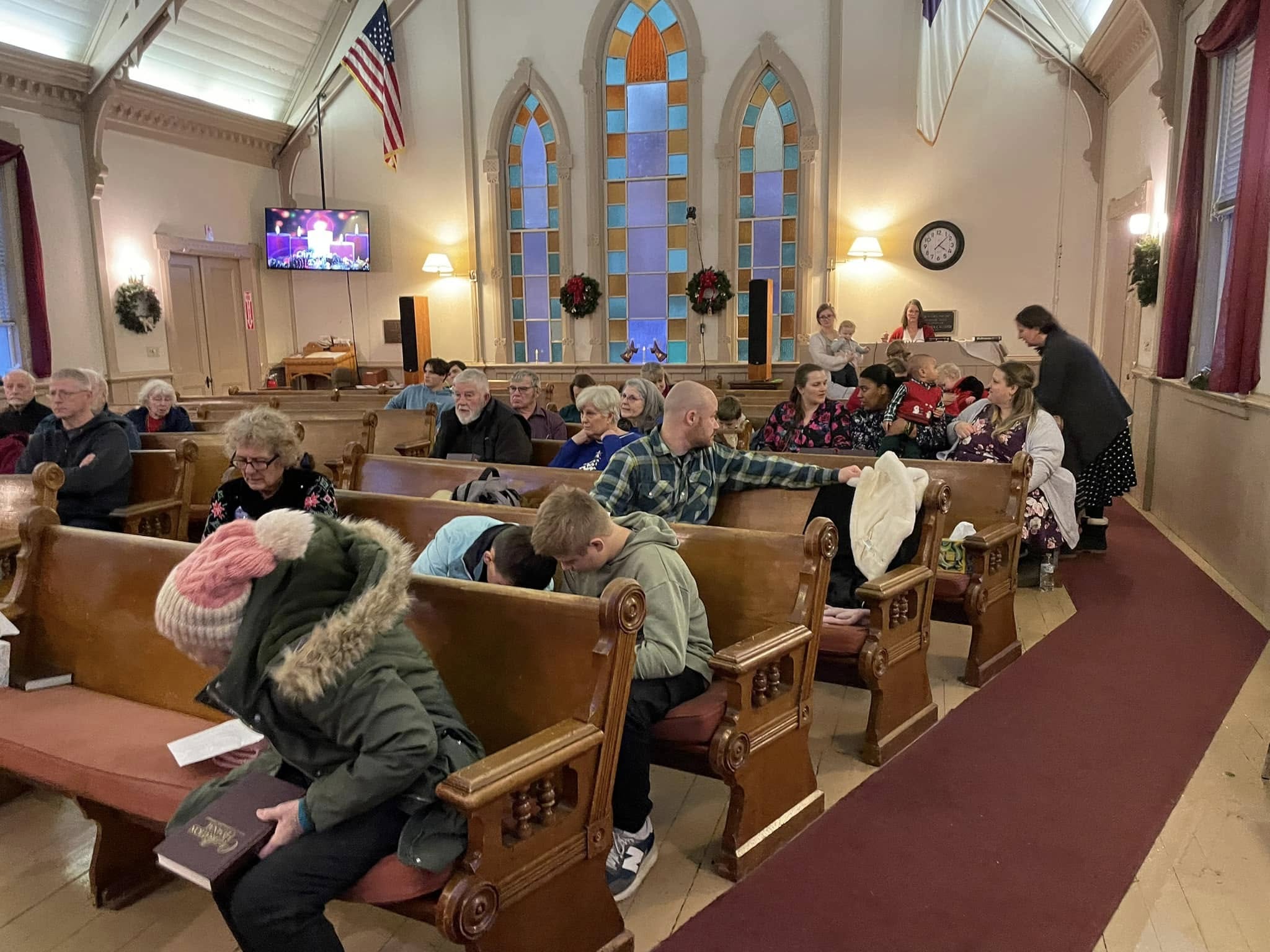 Friendly congregation gathering outside Tremont Community Church on a sunny day in Bass Harbor, Maine